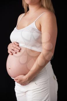 Close Up Portrait Of 6 months Pregnant Woman On Black Background