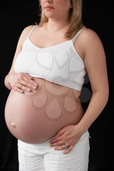 Close Up Portrait Of 9 months Pregnant Woman On Black Background