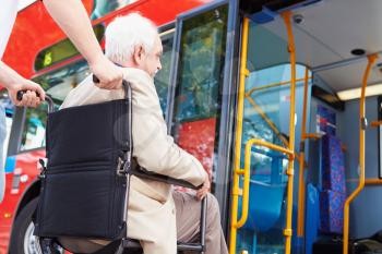 Senior Couple Boarding Bus Using Wheelchair Access Ramp