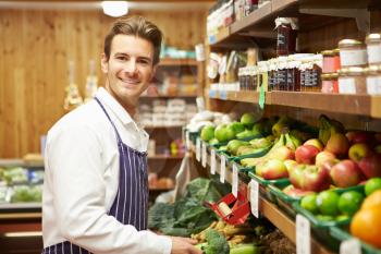 Male Sales Assistant At Vegetable Counter Of Farm Shop