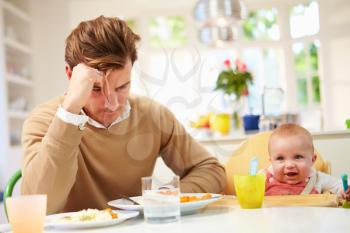 Father Feeling Depressed At Baby's Mealtime