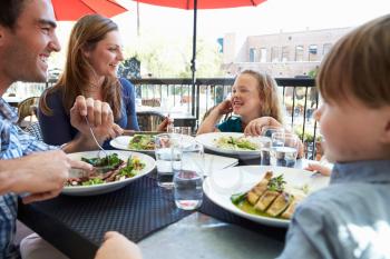 Family Enjoying Meal At Outdoor Restaurant