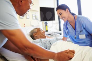 Nurse Talking To Senior Couple In Hospital Room