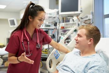 Young Male Patient Talking To Female Nurse In Emergency Room
