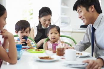 Asian Family Having Breakfast Before Husband Goes To Work