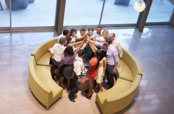Businesspeople Giving Each Other High Five In Office Lobby
