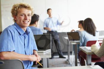 Male High School Student Using Laptop In Classroom