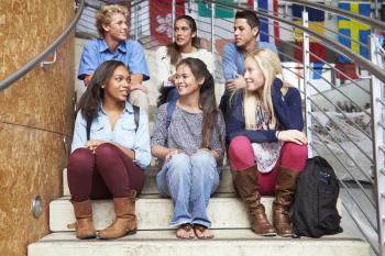 Group Of High School Students Sitting Outside Building