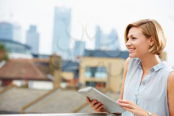 Woman On Roof Terrace Using Digital Tablet