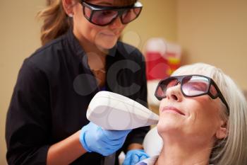 Woman Having Laser Treatment At Beauty Clinic