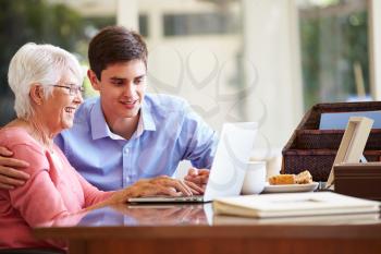 Teenage Grandson Helping Grandmother With Laptop