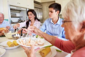 Multi-Generation Family Sitting Around Table Eating Meal