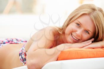 Young Woman On Holiday Relaxing By Swimming Pool