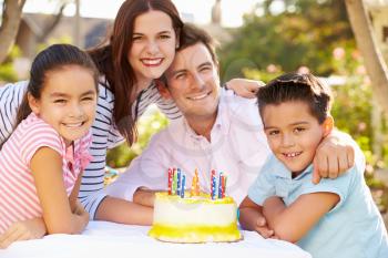 Family Celebrating Birthday Outdoors With Cake
