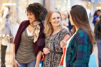 Three Female Friends Shopping In Mall Together