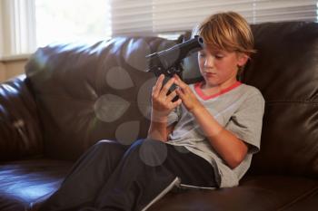 Boy Playing With Parent's Gun He Has Found At Home