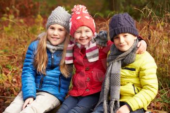 Three Children On Walk Through Winter Woodland