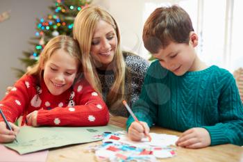 Mother And Children Writing Letter To Santa Together