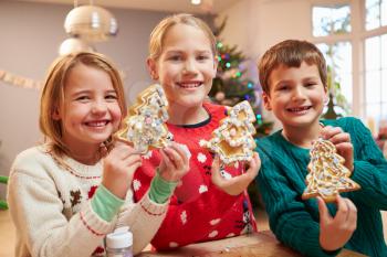 Three Children Showing Decorated Christmas Cookies
