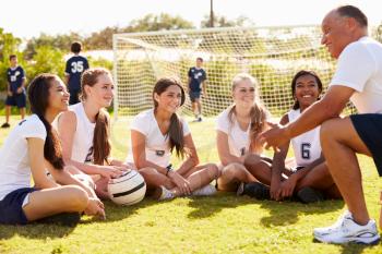 Coach Giving Team Talk To Female High School Soccer Team