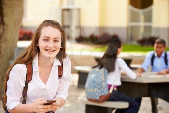 Female High School Student Using Phone On School Campus