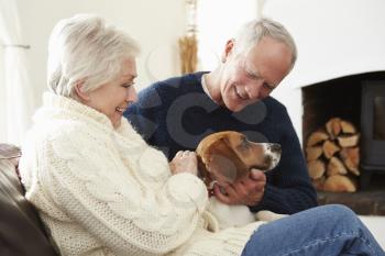 Senior Couple Relaxing At Home With Pet Dog