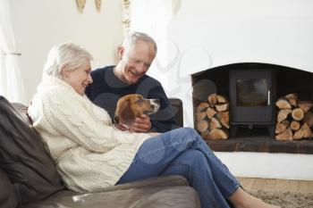 Senior Couple Relaxing At Home With Pet Dog
