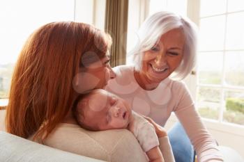 Mother And Grandmother With Sleeping Newborn Baby Daughter