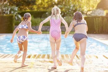Group Of Girls Jumping Into Outdoor Swimming Pool