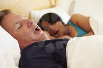 Couple Asleep In Bed With Man Snoring