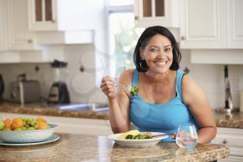 Overweight Woman Eating Healthy Meal in Kitchen