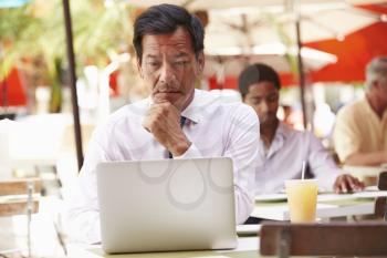 Businessman Working On Laptop In Outdoor Caf