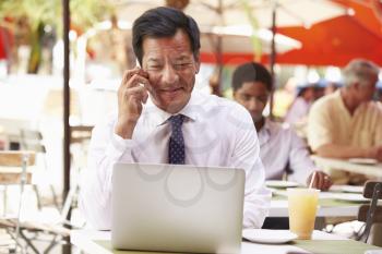Businessman Working On Laptop In Outdoor Caf