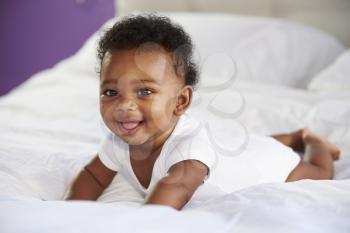 Cute Baby Lying On Tummy In Parent's Bed