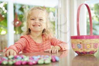 Girl With Chocolate Easter Eggs And Basket At Home