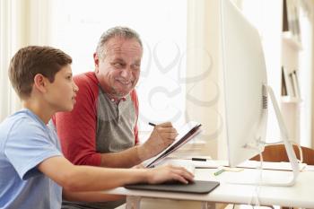 Grandson Teaching Grandfather To Use Computer