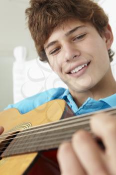 Teenage boy playing acoustic guitar