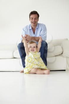 Doting father with baby daughter at home