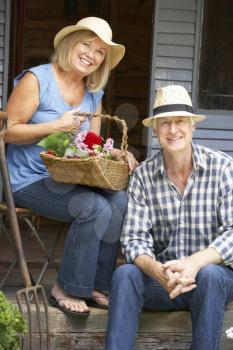 Senior couple sitting on veranda with flowers