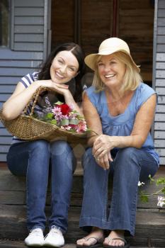 Adult mother and daughter sitting on veranda