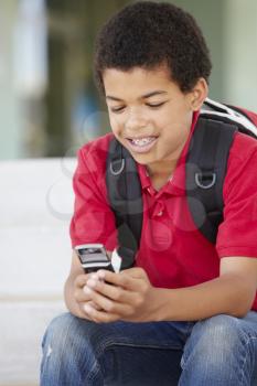 Pre teen boy with phone at school