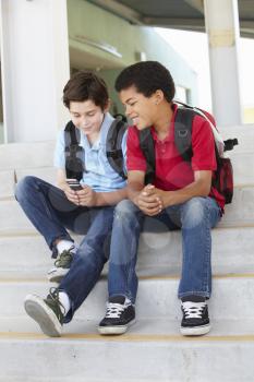 Pre teen boys with phone at school