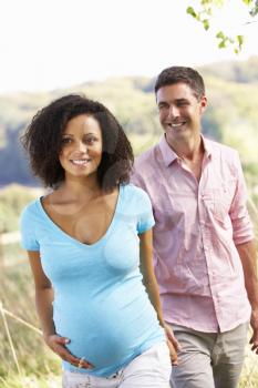 Expectant couple outdoors in countryside