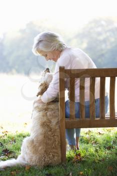 Senior woman sitting outdoors with dog
