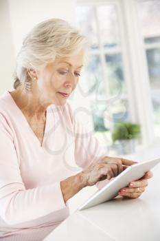 Senior woman using tablet at home