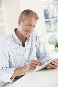 Senior man using tablet at home