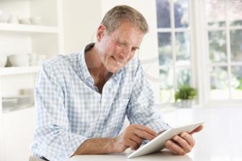 Senior man using tablet at home