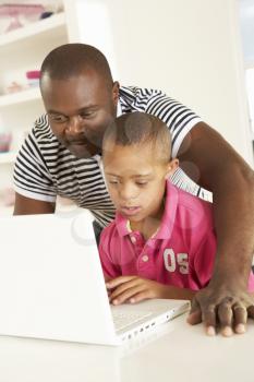 Father and Downs Syndrome son with laptop