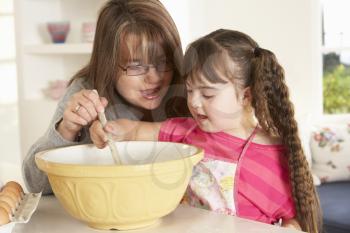 Girl with Downs Syndrome baking with mother