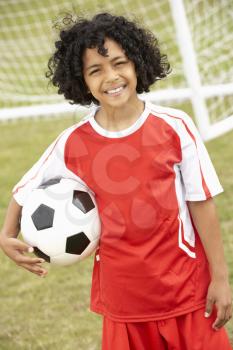 Portrait boy in football kit with ball